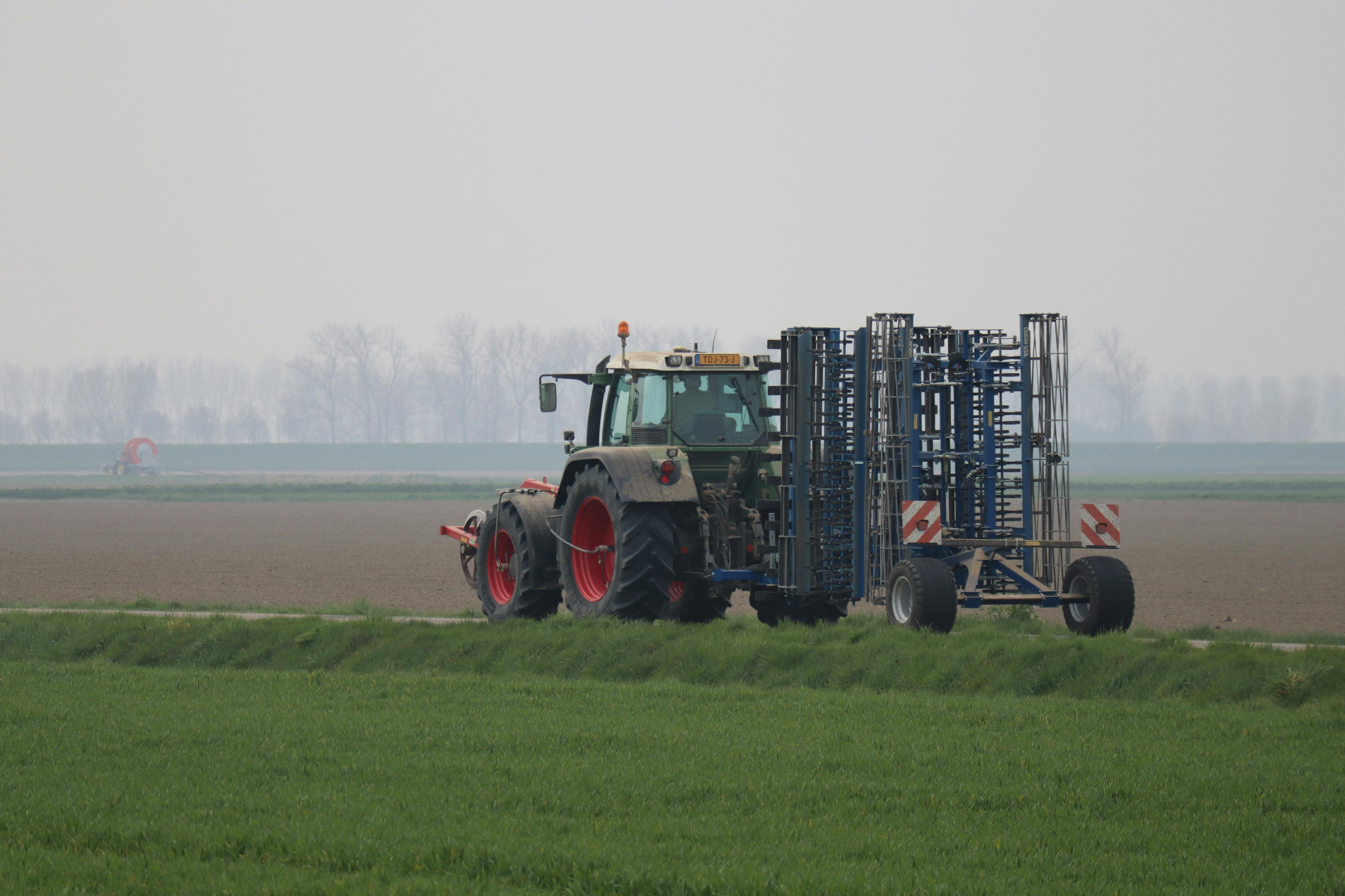 Project Categories A tractor working on agricultural land during an overcast day, depicting modern farming practices.