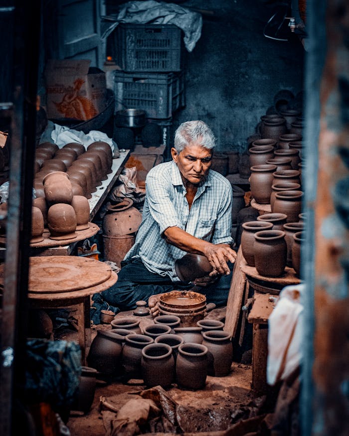 Services potter sitting and working in workshop 19179109